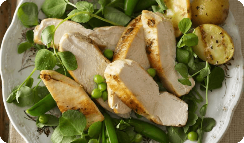 sliced chicken breast on a plate of green salad